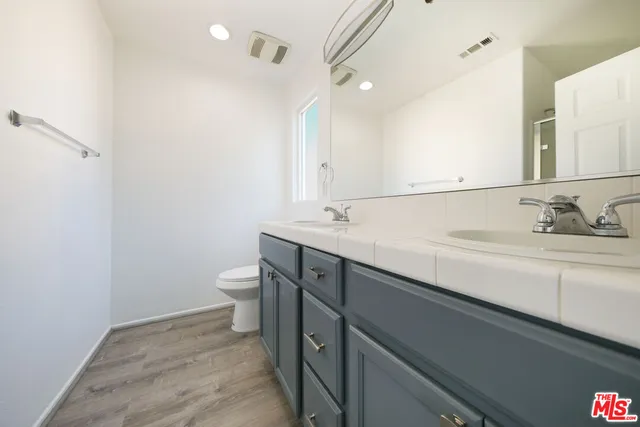 a bathroom with a sink a toilet and a mirror