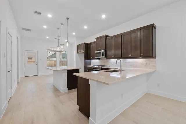 a kitchen with stainless steel appliances granite countertop a sink stove and refrigerator