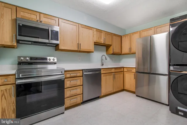 a kitchen with stainless steel appliances granite countertop a refrigerator stove and microwave