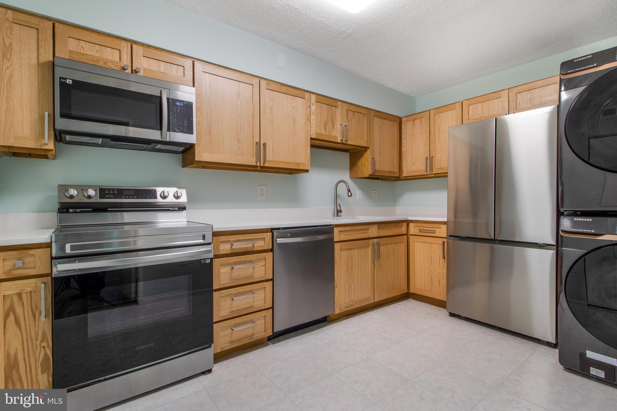 a kitchen with stainless steel appliances granite countertop a refrigerator stove and microwave