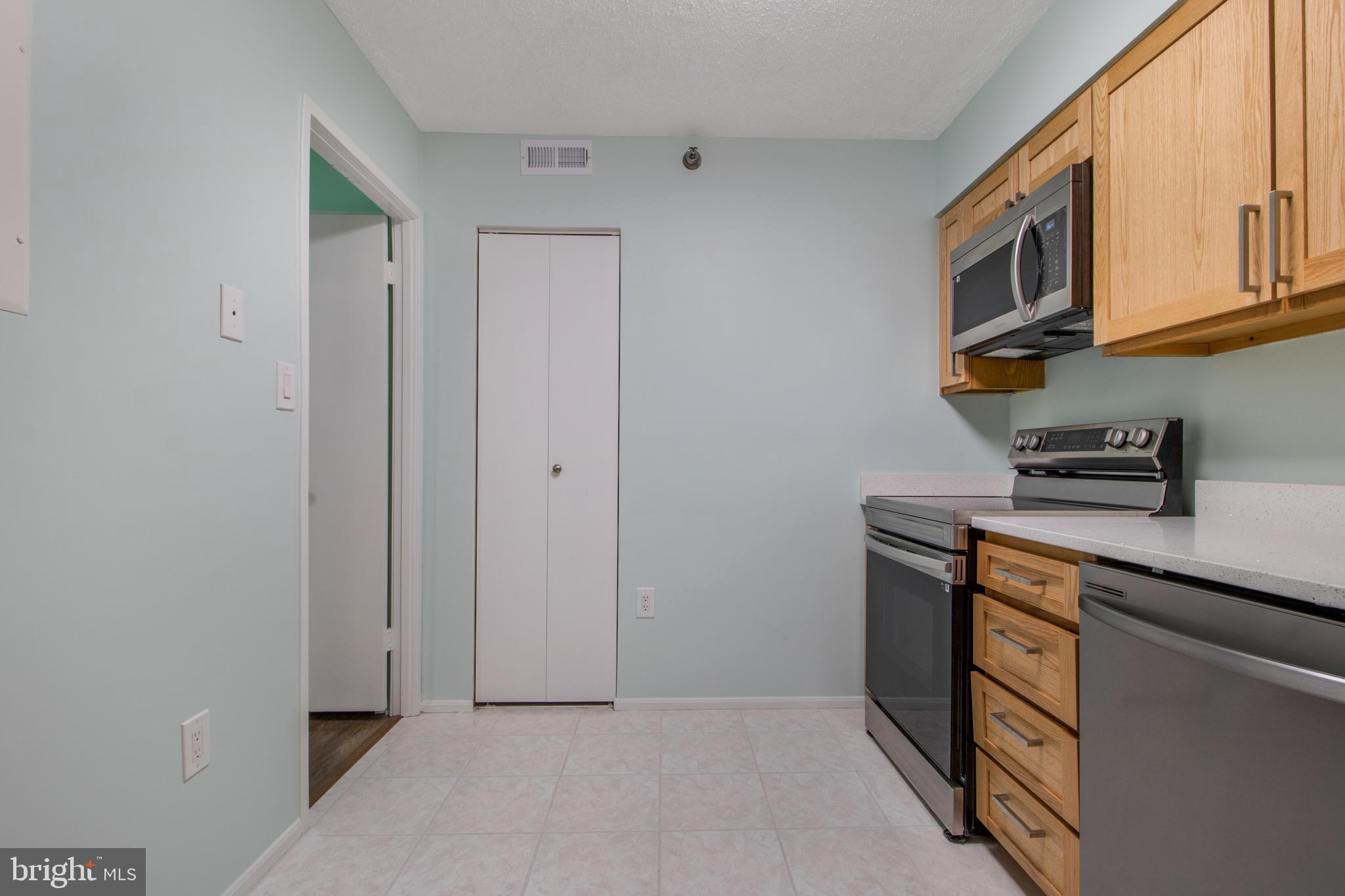 15115 Interlachen Drive, Unit 31020 Silver Spring, MD 20906 - Photo 13 of 48 a kitchen with stainless steel appliances granite countertop a refrigerator and a microwave