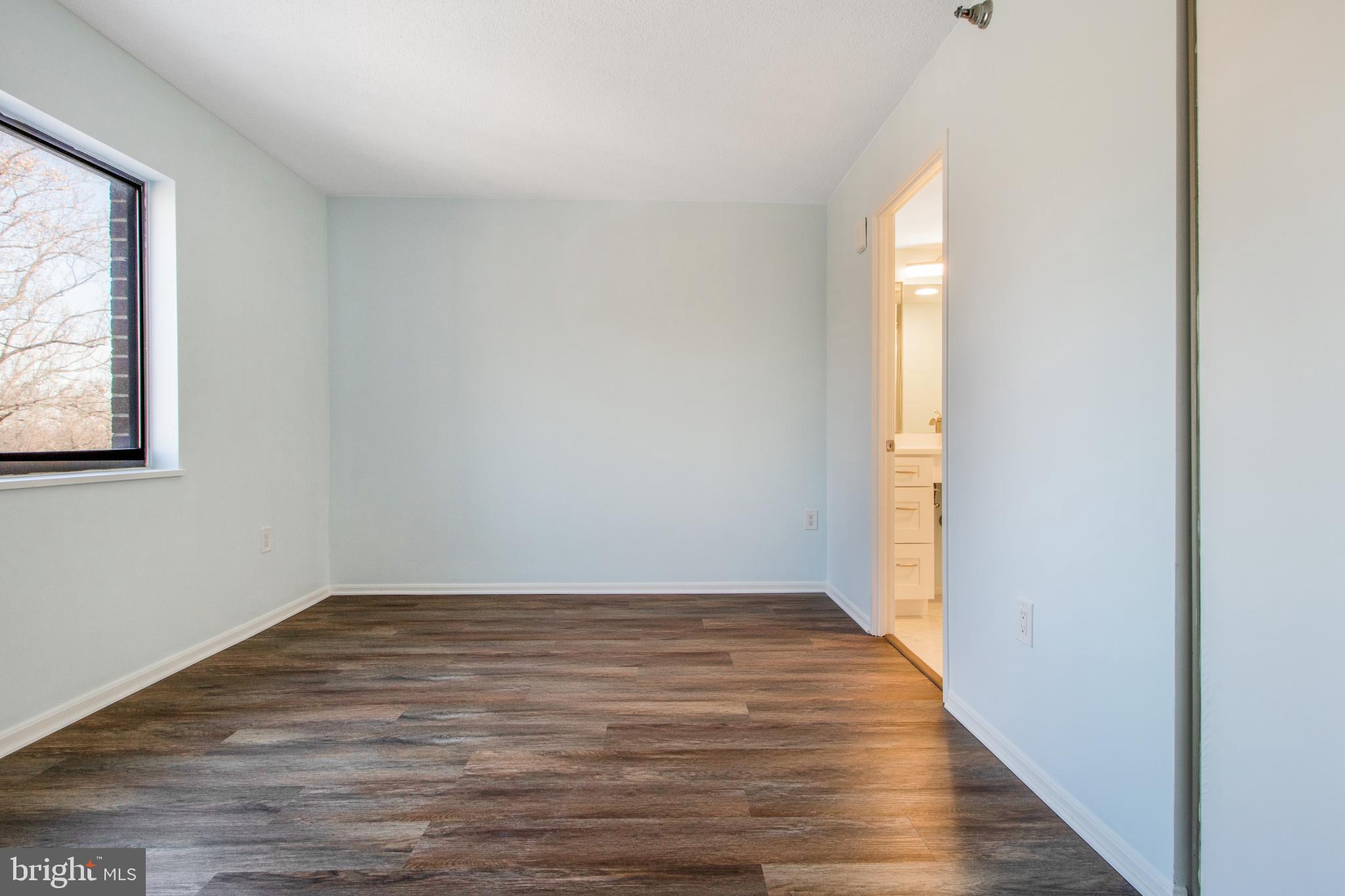15115 Interlachen Drive, Unit 31020 Silver Spring, MD 20906 - Photo 17 of 48 a view of an empty room with wooden floor and a window