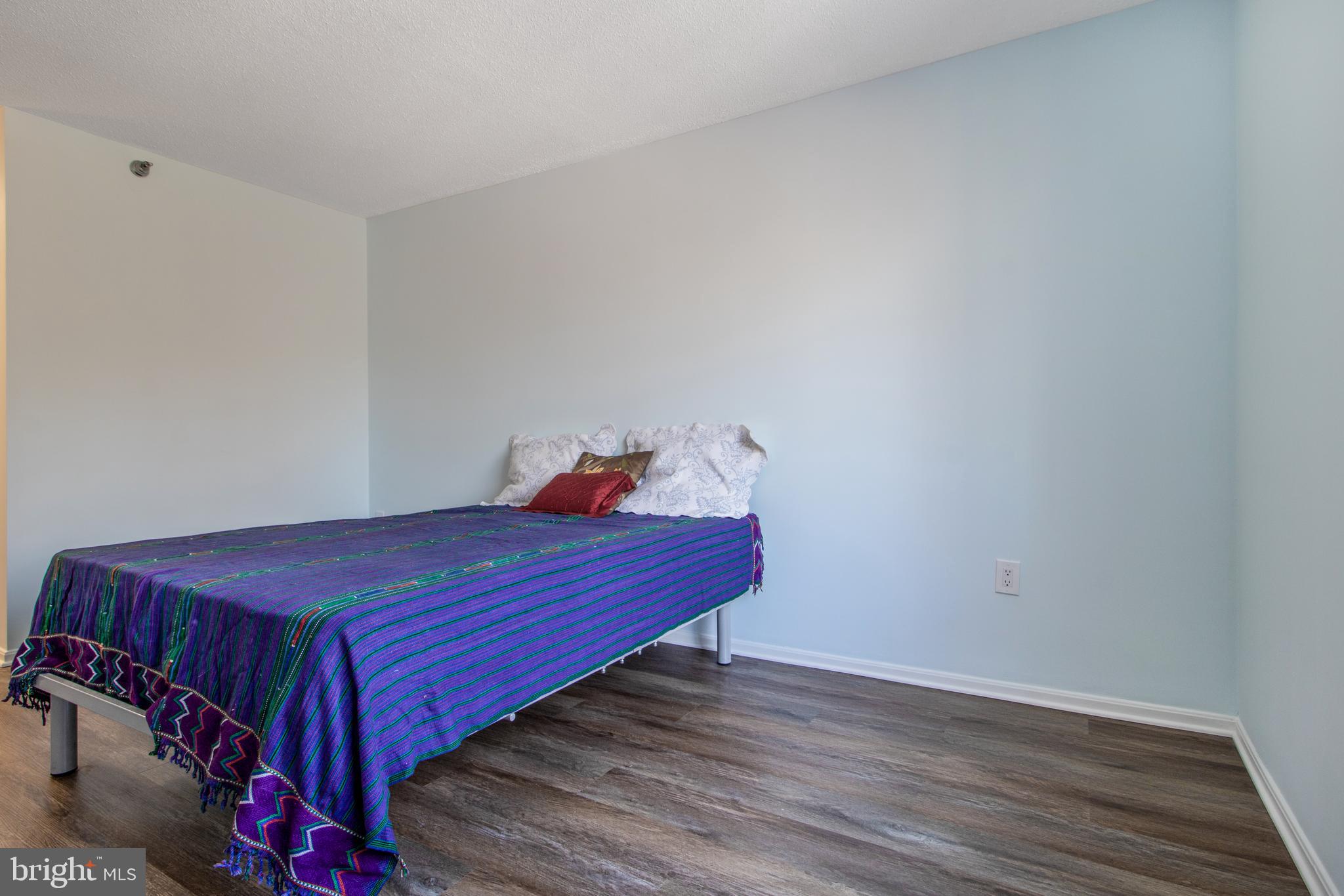 15115 Interlachen Drive, Unit 31020 Silver Spring, MD 20906 - Photo 32 of 48 a bed room with a bed and wooden floor