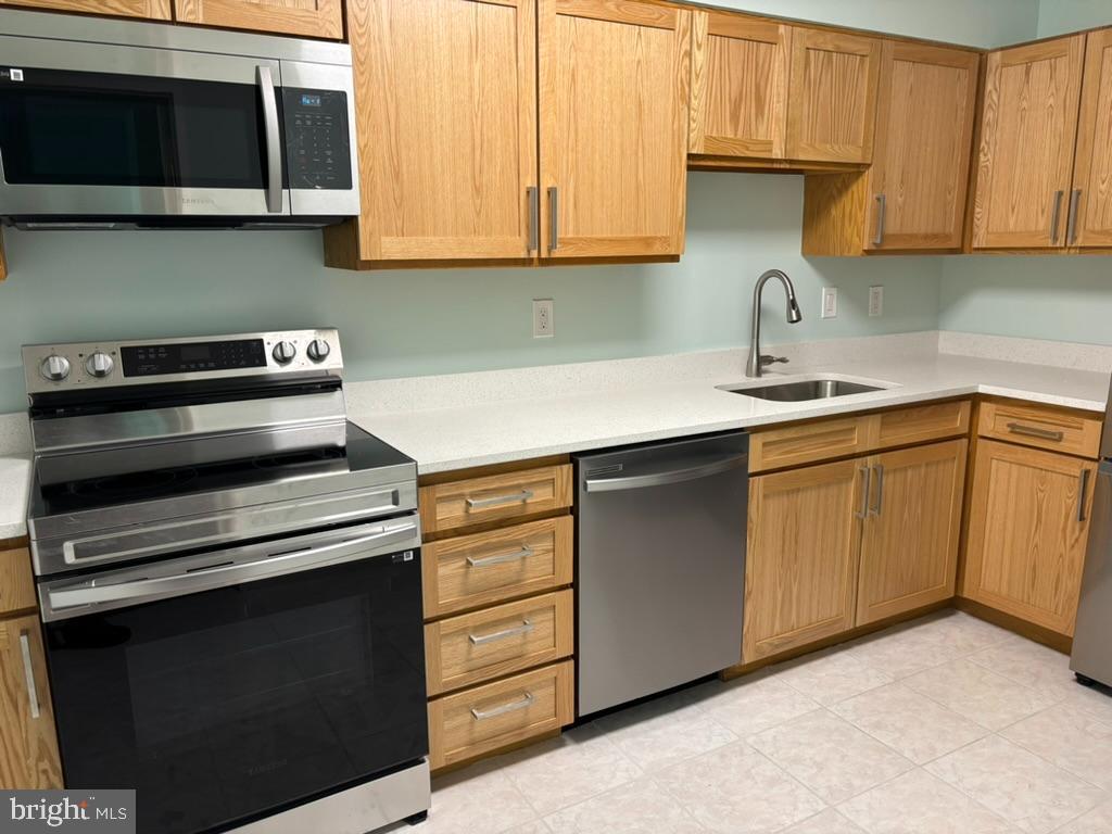15115 Interlachen Drive, Unit 31020 Silver Spring, MD 20906 - Photo 6 of 48 a kitchen with cabinets appliances and a sink