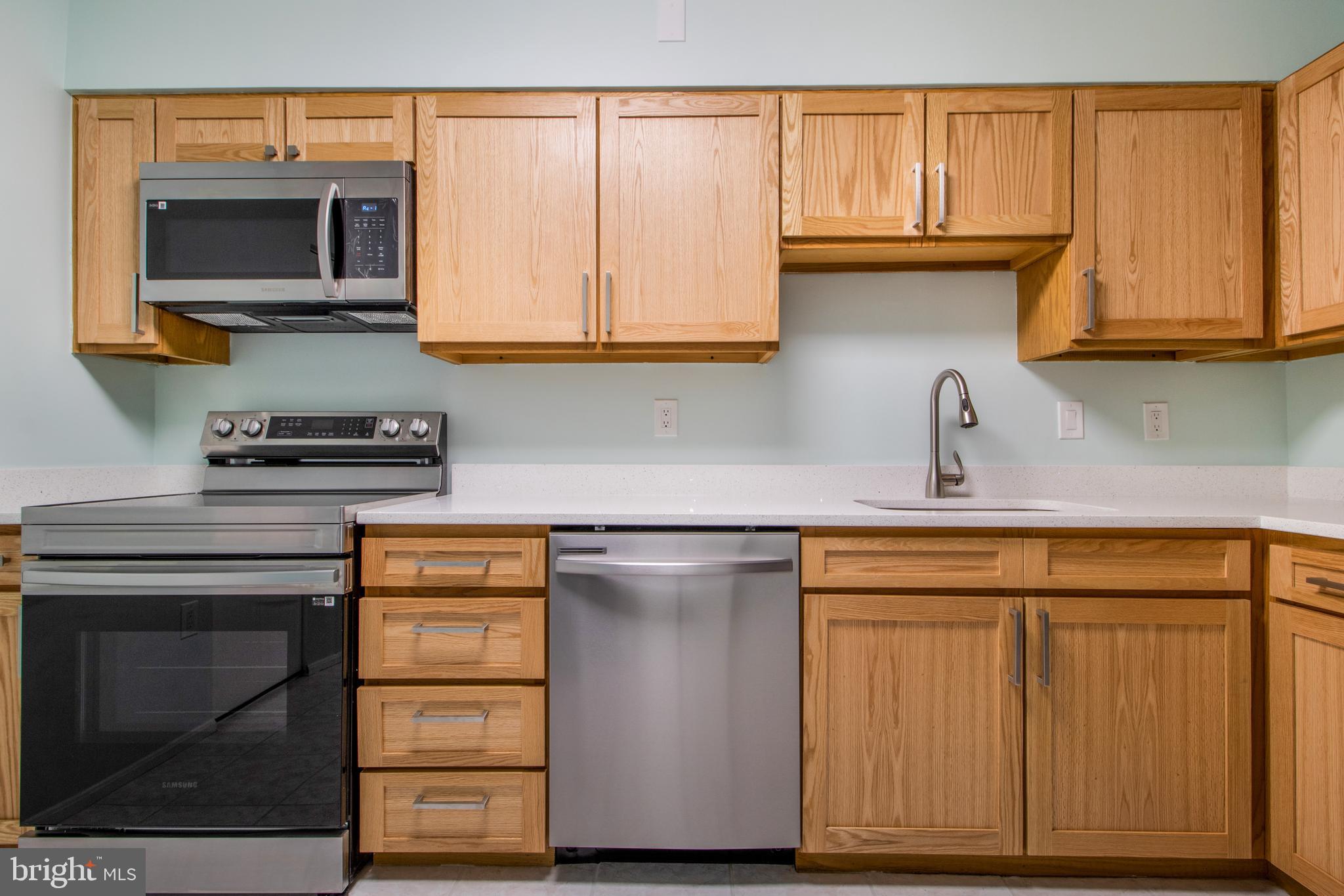 15115 Interlachen Drive, Unit 31020 Silver Spring, MD 20906 - Photo 7 of 48 a kitchen with stainless steel appliances granite countertop a sink and a microwave