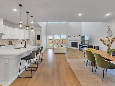 a kitchen with stainless steel appliances kitchen island granite countertop a dining table chairs and view living room