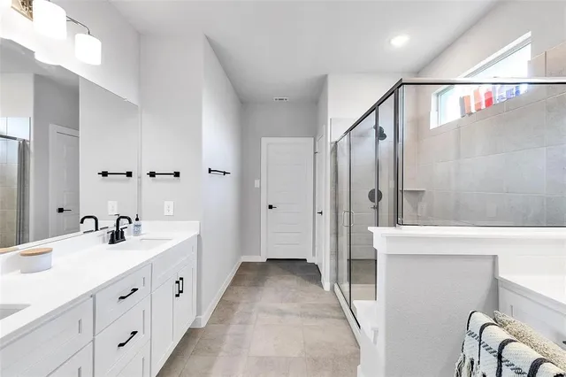 a spacious bathroom with double vanity and mirrors