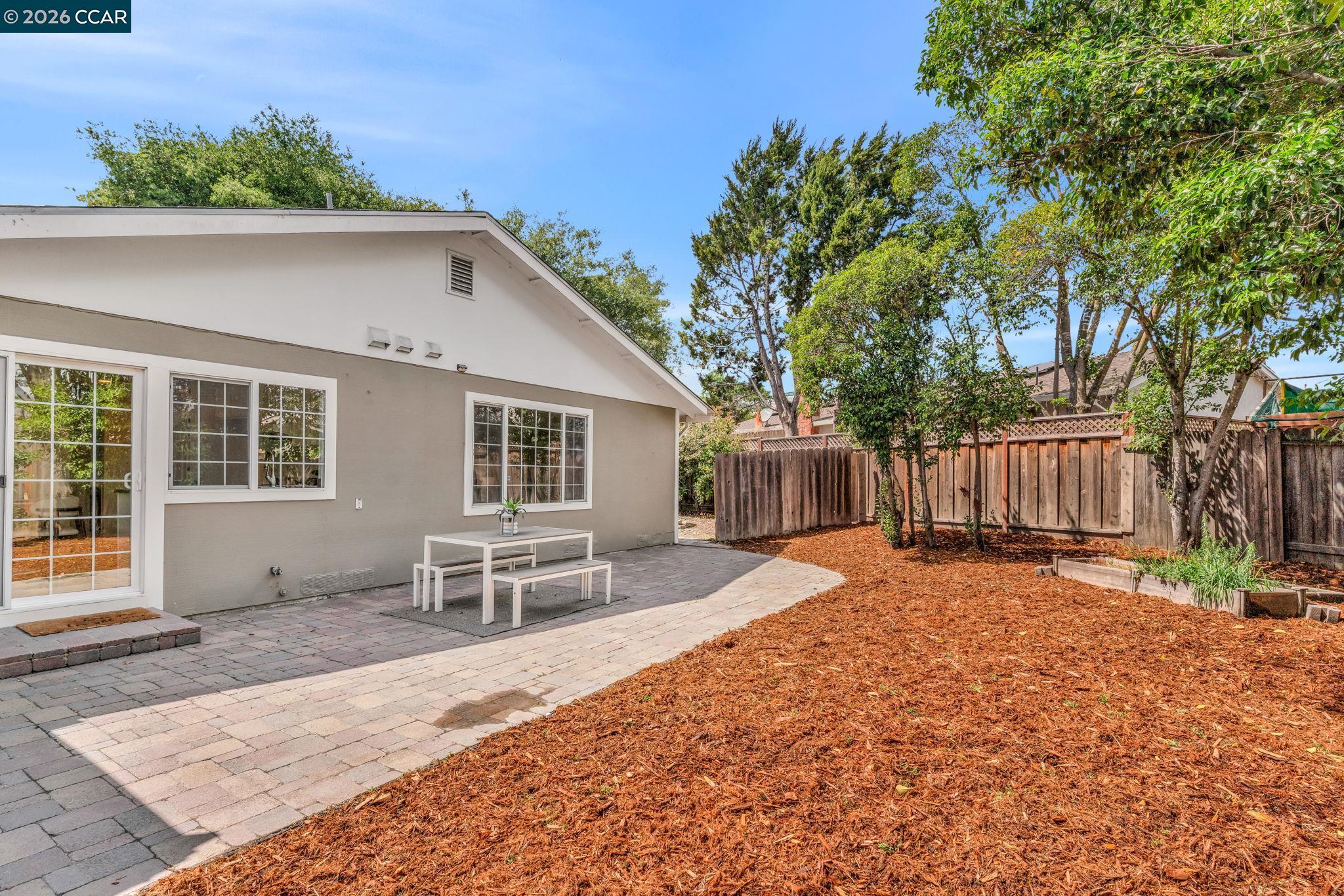 32 Yale Court San Ramon, CA 94583 - Photo 37 of 40 a backyard of a house with table and chairs floor to ceiling window and wooden fence
