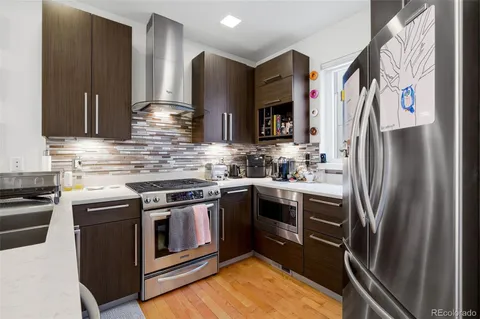 a kitchen with stainless steel appliances granite countertop a stove a refrigerator and a sink