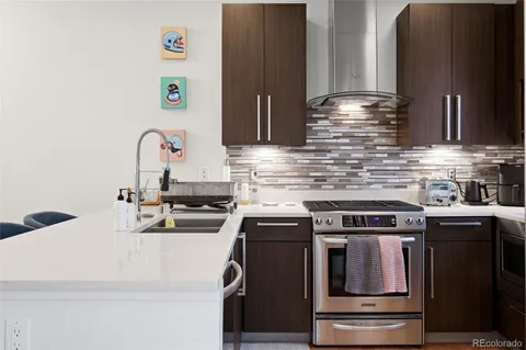 a kitchen with kitchen island stainless steel appliances wooden cabinets and a sink