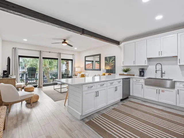 a living room with furniture kitchen view and a wooden floor
