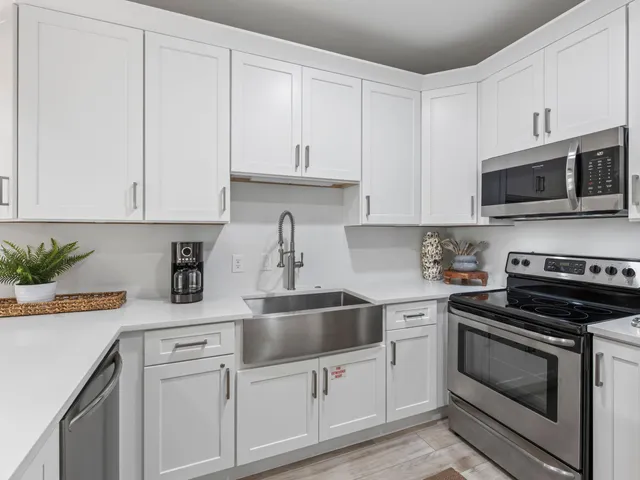 a kitchen with white cabinets and appliances