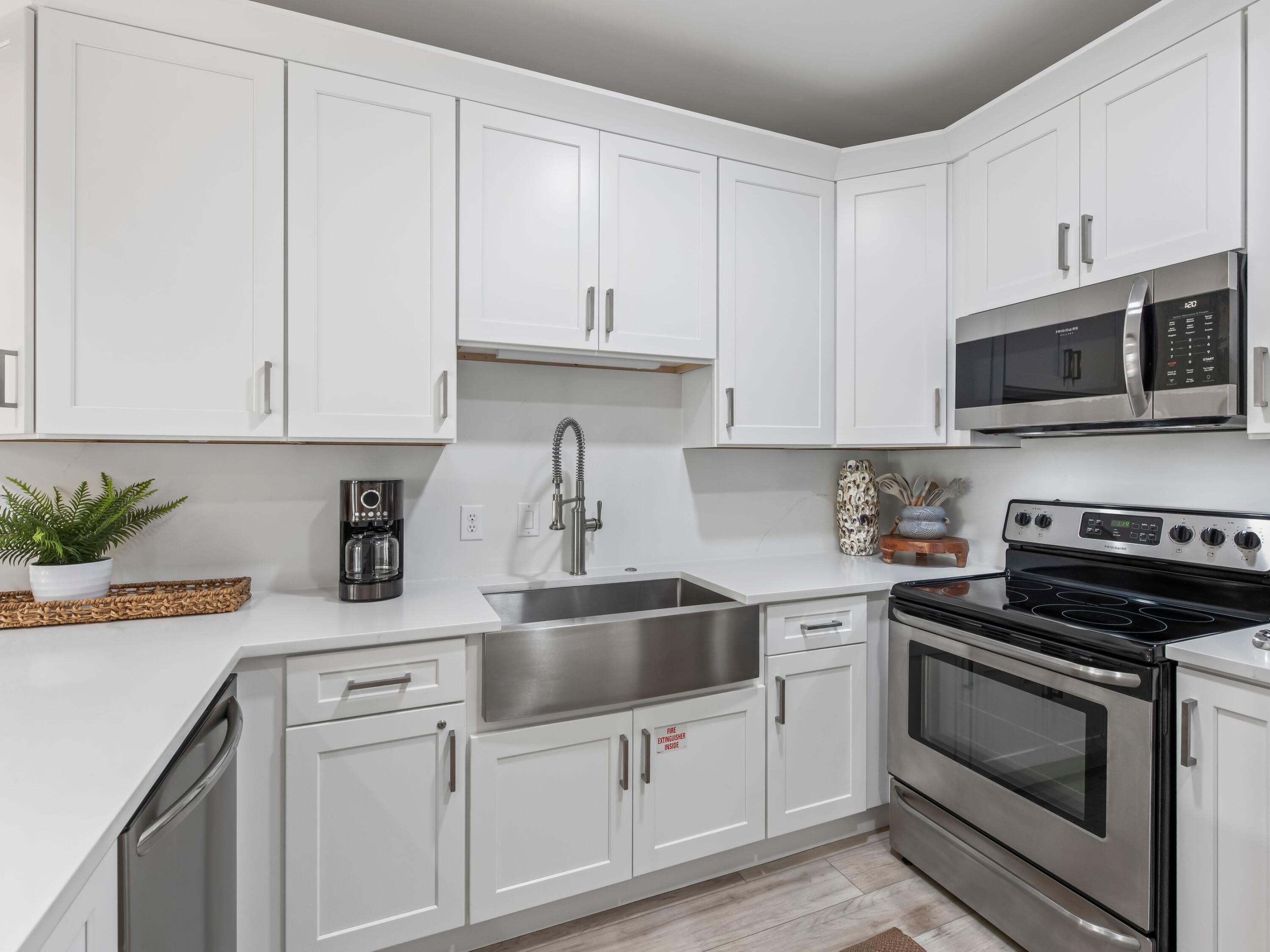 3604 East County Highway 30A, Unit D5 Santa Rosa Beach, FL 32459 - Photo 20 of 45 a kitchen with white cabinets and stainless steel appliances