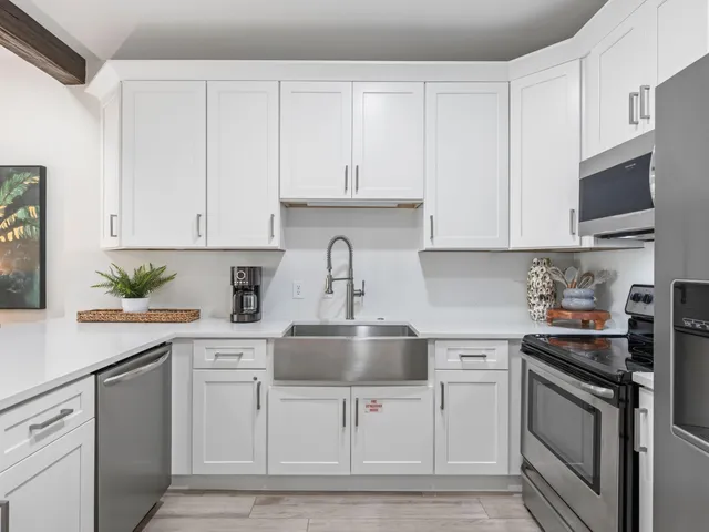 a kitchen with stainless steel appliances a refrigerator a stove a microwave and cabinets