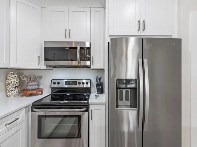 a kitchen with white cabinets and white appliances