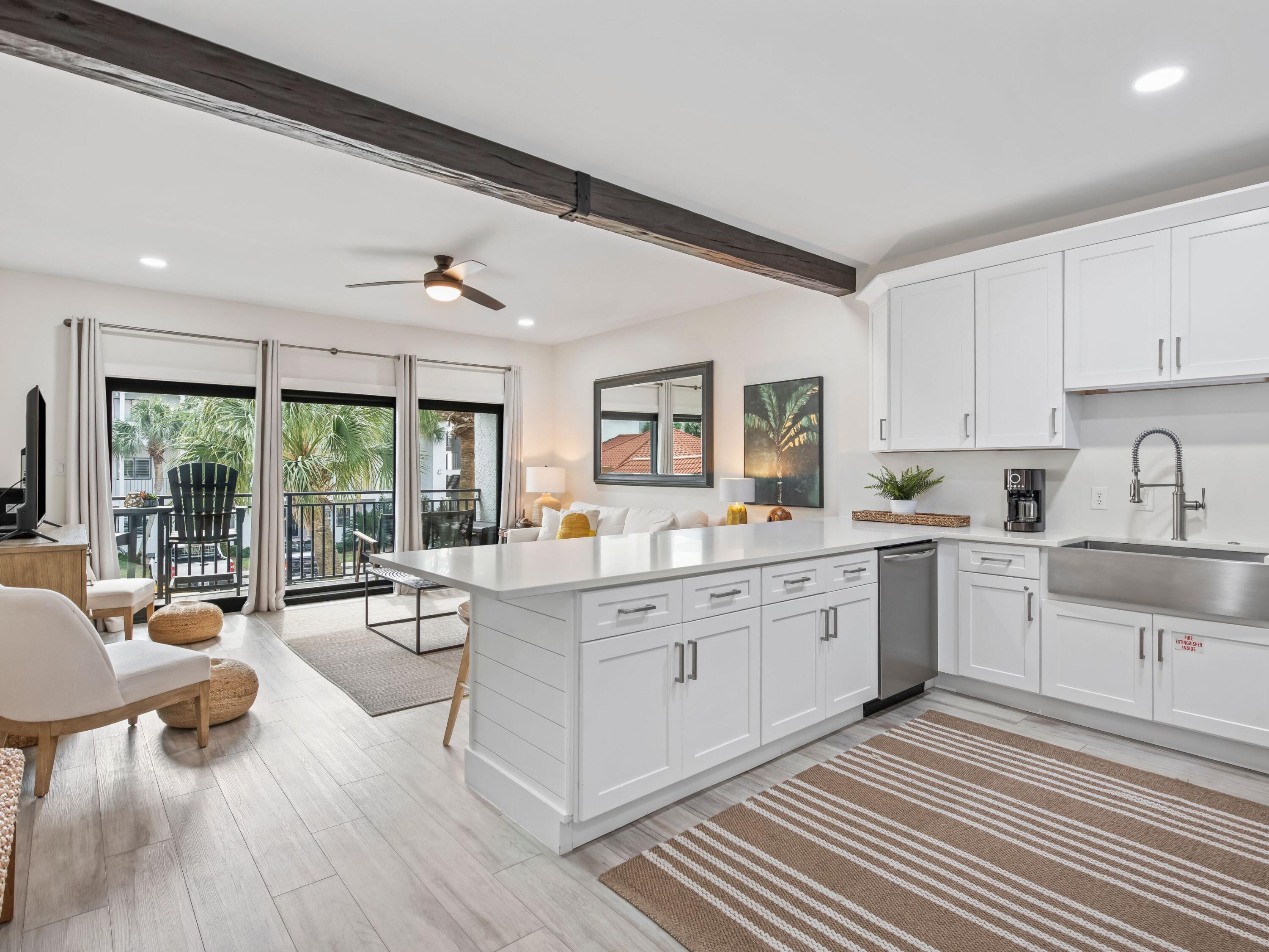 3604 East County Highway 30A, Unit D5 Santa Rosa Beach, FL 32459 - Photo 24 of 45 a large white kitchen with wooden floors and white stainless steel appliances