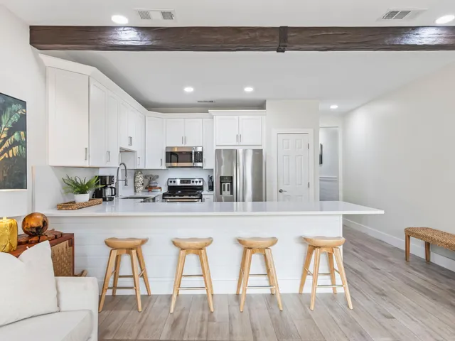 a kitchen with stainless steel appliances granite countertop table chairs sink and cabinets