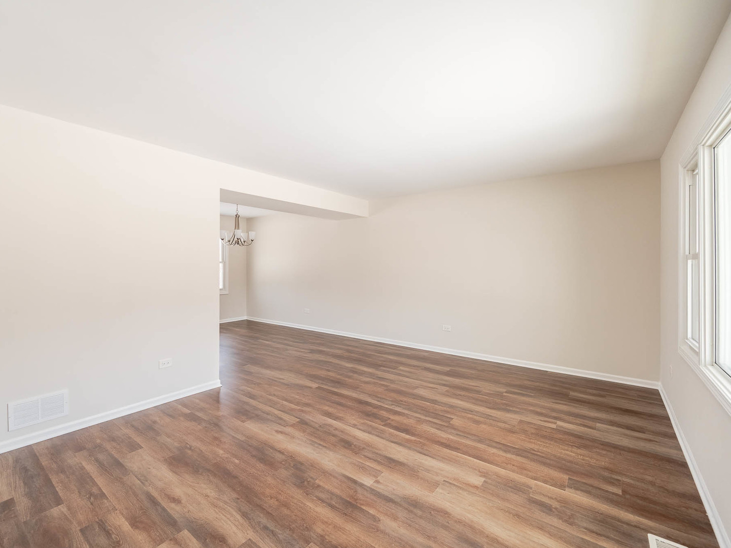 429 6th Street Wheeling, IL 60090 - Photo 4 of 17 a view of an empty room with wooden floor and a window