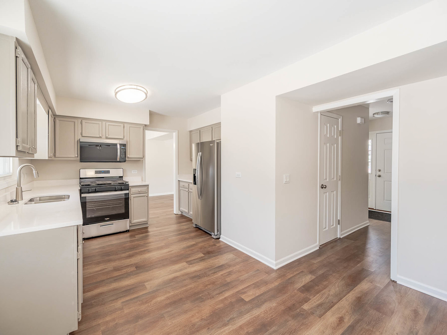 429 6th Street Wheeling, IL 60090 - Photo 6 of 17 a kitchen with granite countertop a refrigerator and a stove top oven