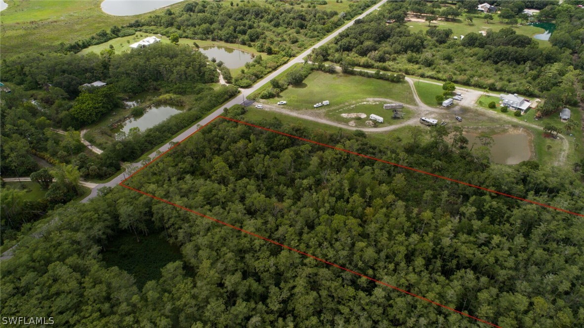 an aerial view of residential houses with outdoor space and trees