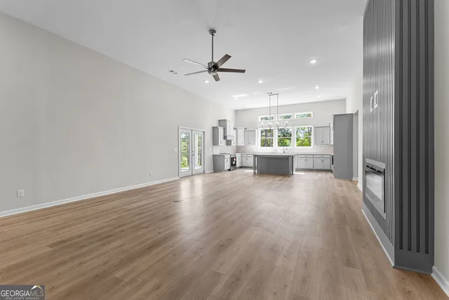 wooden floor in an empty room with a kitchen