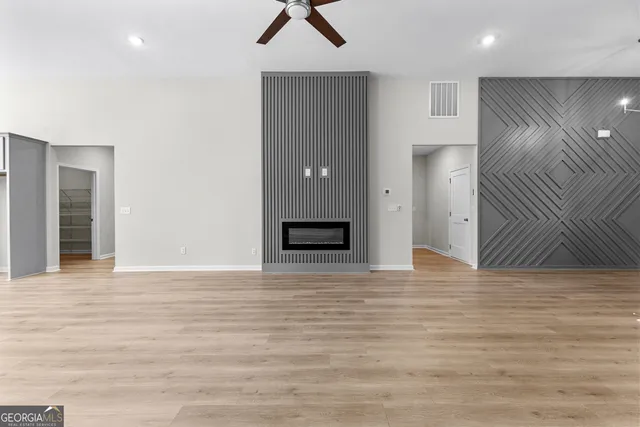 a view of an empty room with wooden floor and cabinet