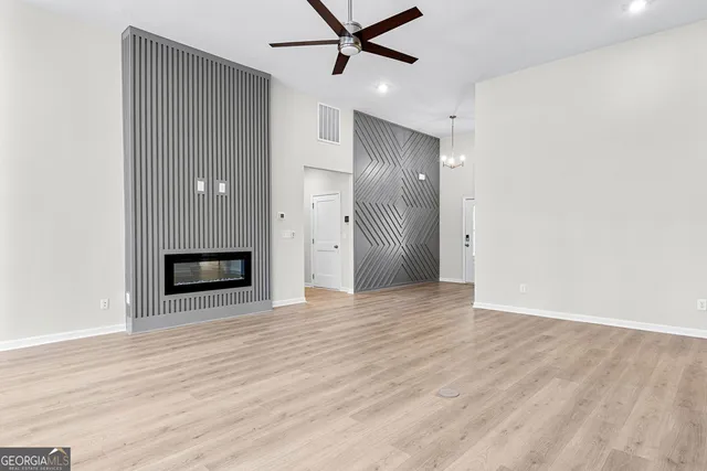 a view of a livingroom with a ceiling fan a ceiling fan and wooden floor