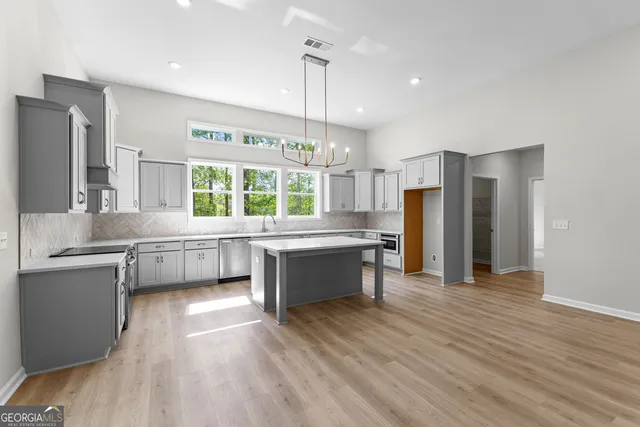 a kitchen with stainless steel appliances a refrigerator and a wooden floor