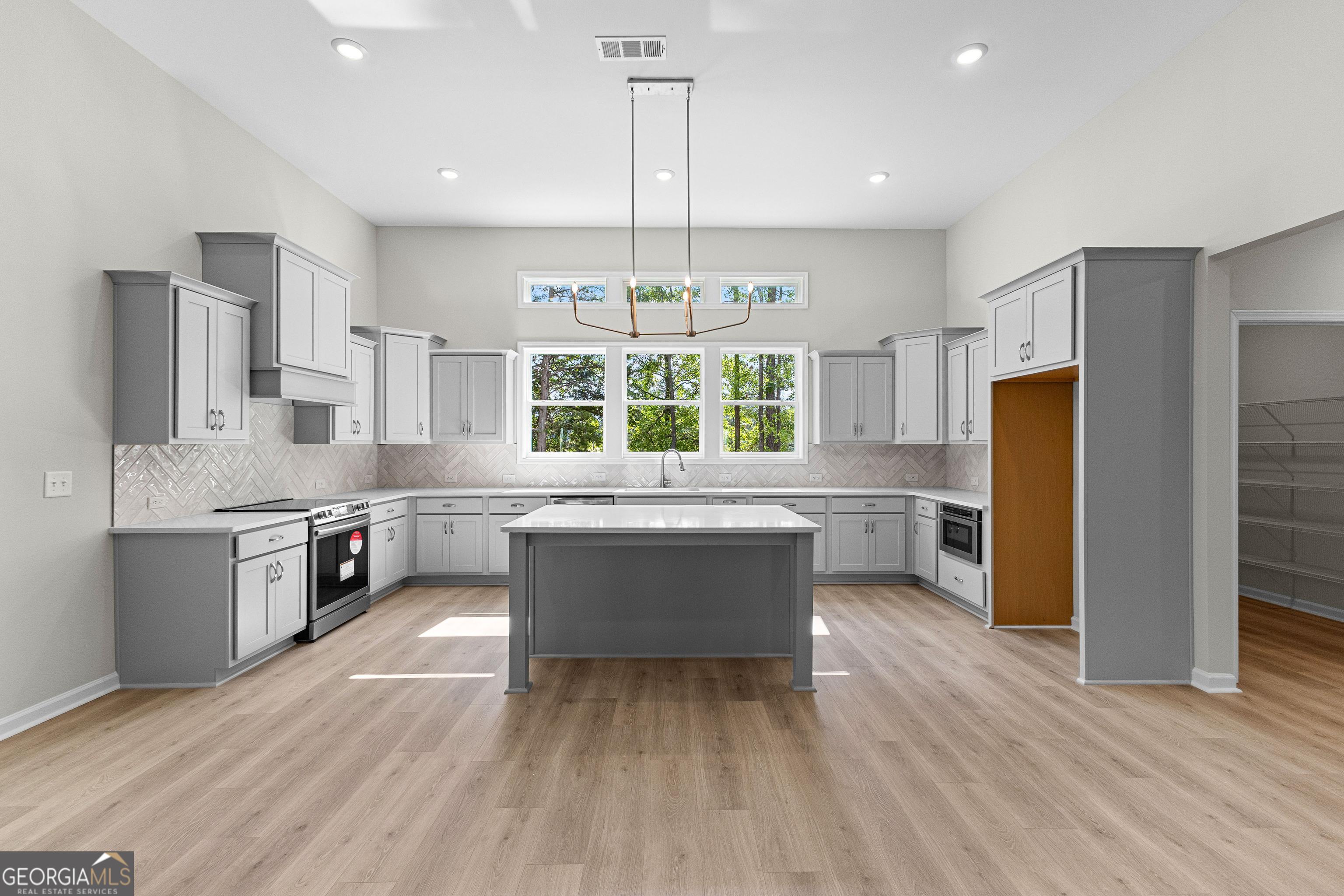 1242 Waymanville Road Thomaston, GA 30286 - Photo 17 of 52 a kitchen with stainless steel appliances granite countertop a refrigerator a sink dishwasher a stove and a dining table with wooden floor