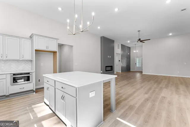 a kitchen that has a lot of cabinets and wooden floor