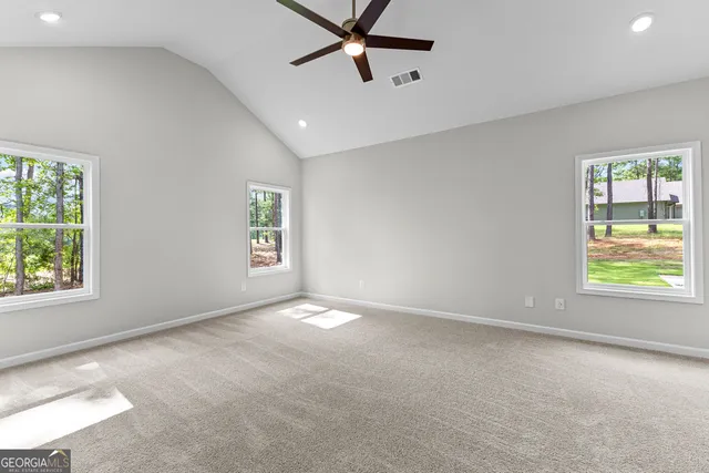 an empty room with windows and fan