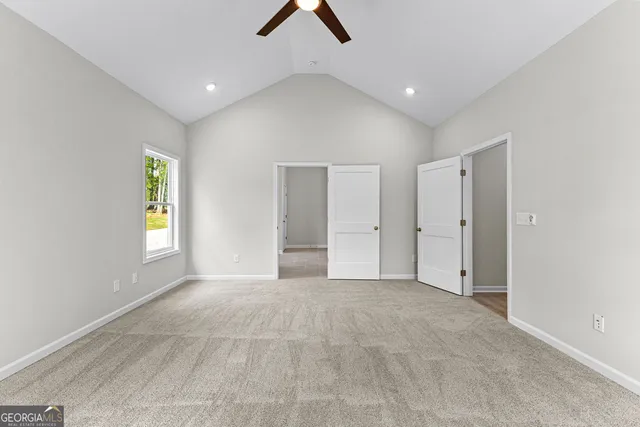 an empty room with ceiling fan and window
