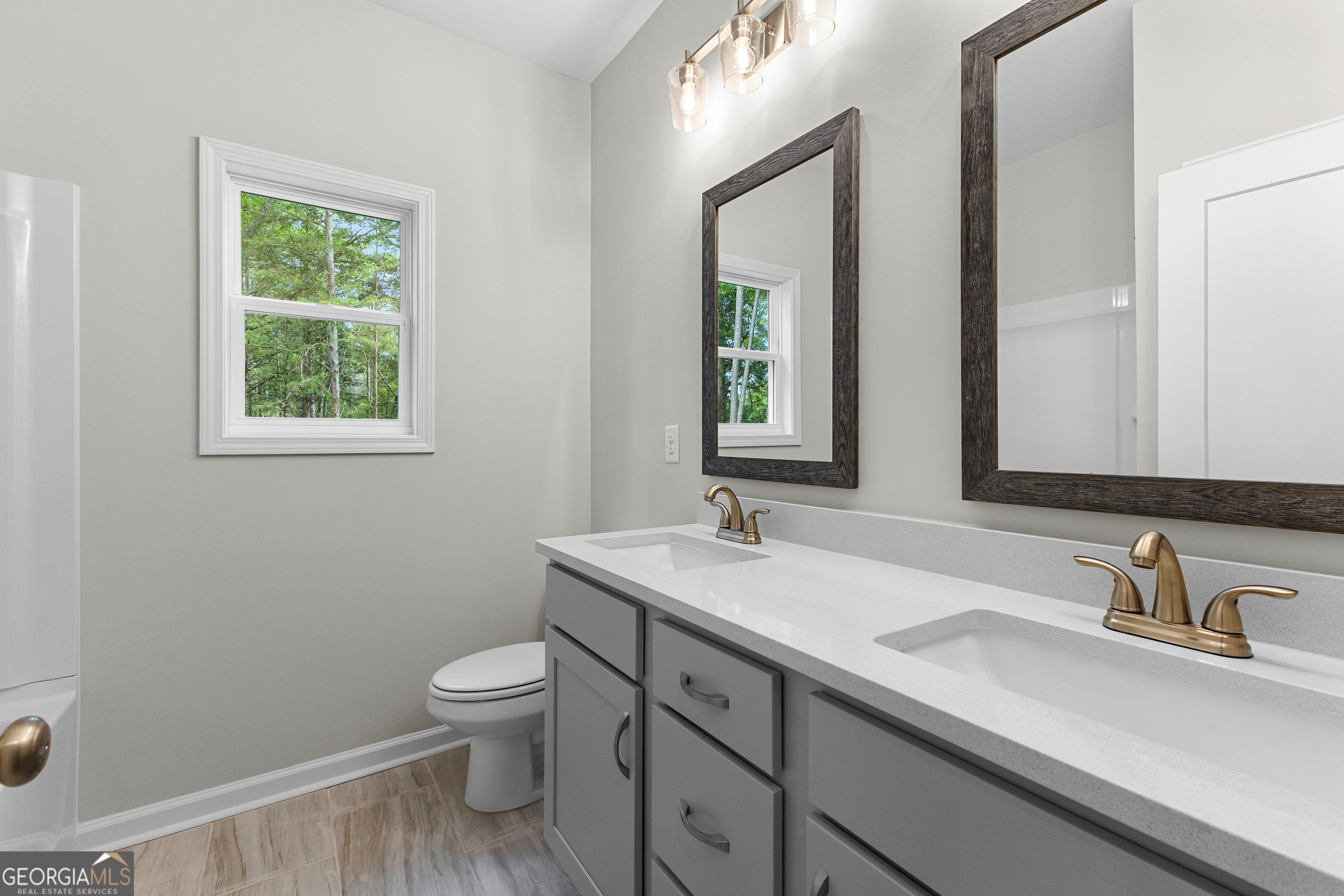 1242 Waymanville Road Thomaston, GA 30286 - Photo 38 of 52 a bathroom with a granite countertop sink a toilet and a mirror