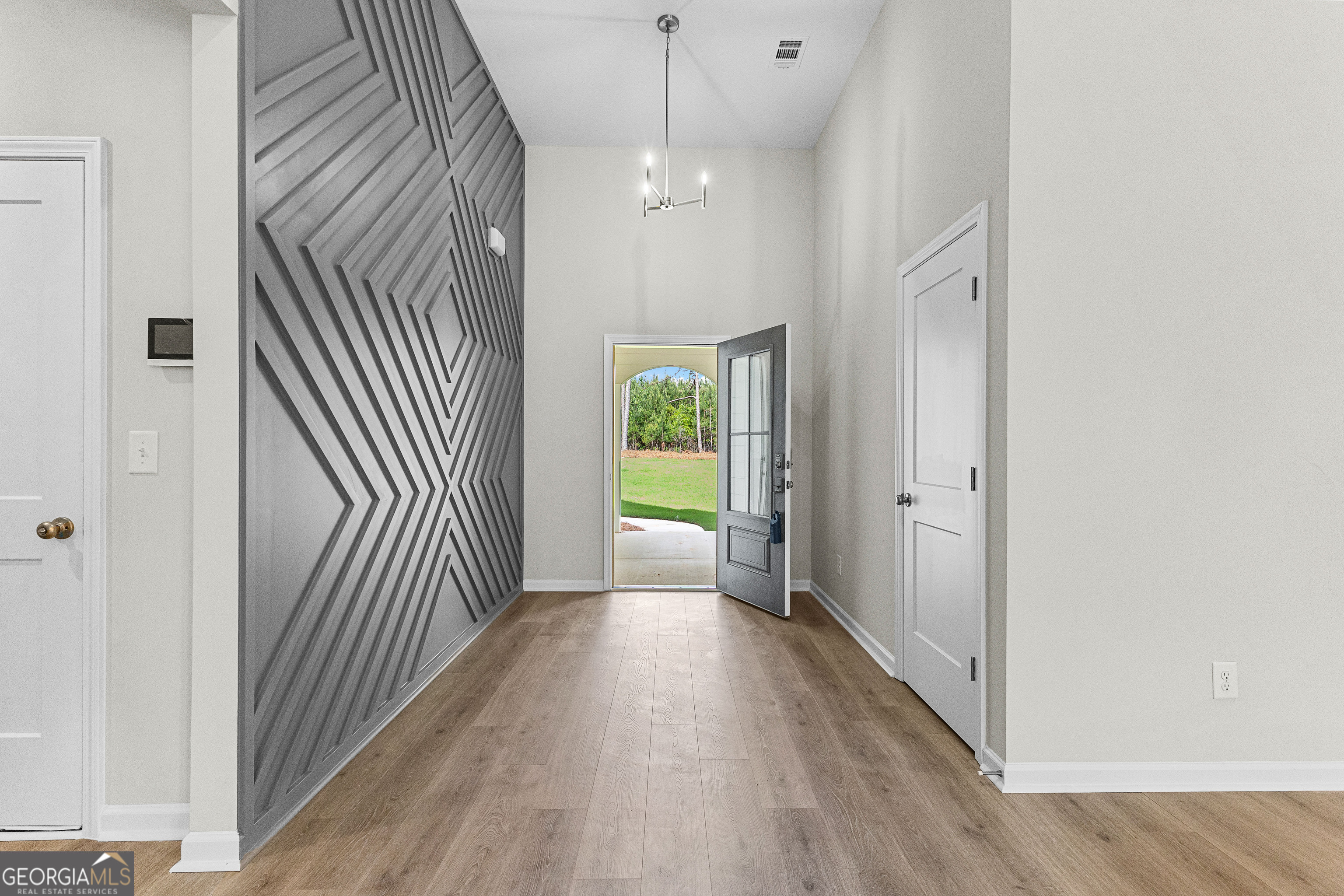 1242 Waymanville Road Thomaston, GA 30286 - Photo 8 of 52 a view of a hallway with wooden floor and a bathroom