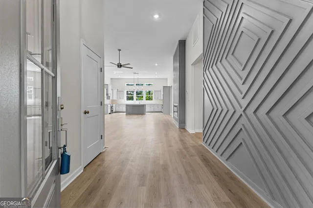 a view of a hallway with wooden floor and staircase