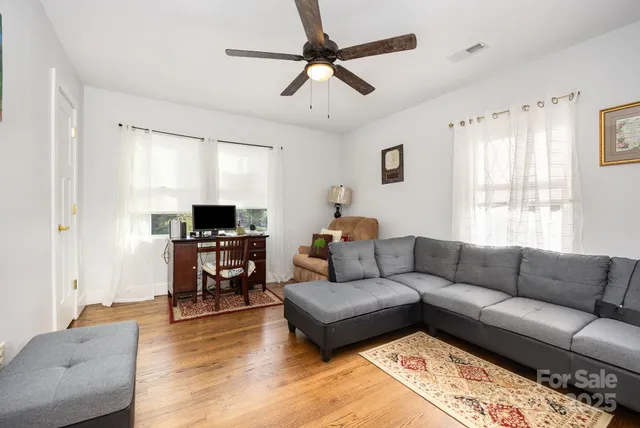 a living room with furniture flat screen tv and window