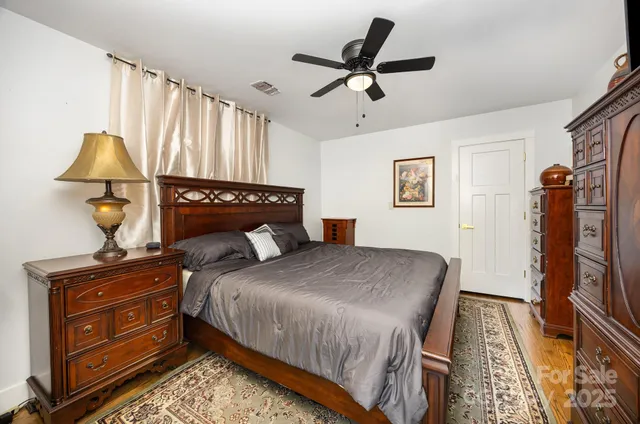 a bedroom with a bed and a flat tv screen on the dresser