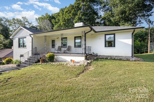 a view of a house with backyard and sitting area