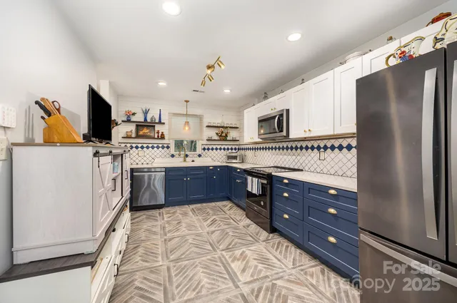 a kitchen with stainless steel appliances granite countertop a refrigerator and a stove top oven