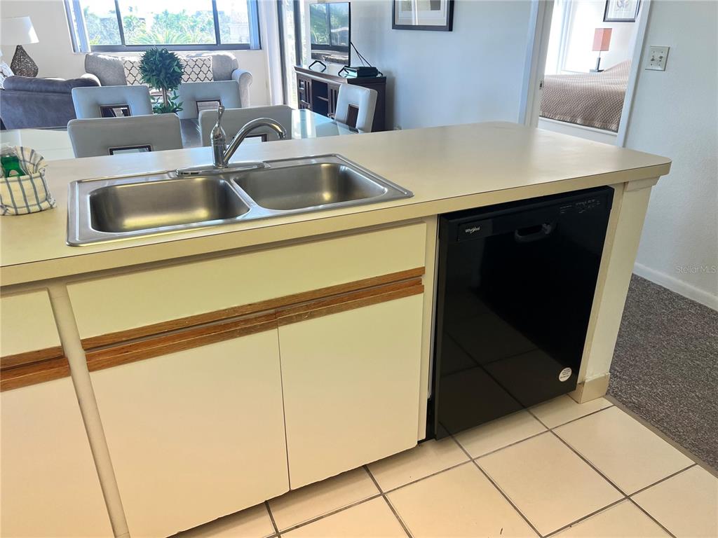 1001 Point Of Rocks Road, Unit 408 Sarasota, FL 34242 - Photo 7 of 34 a kitchen with a sink and a refrigerator