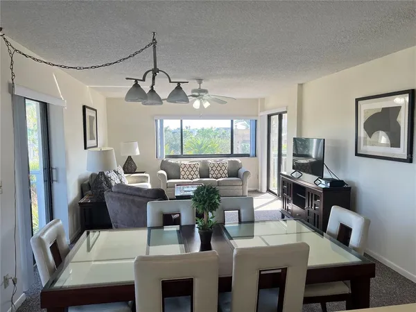 a living room with furniture a dining table and a chandelier