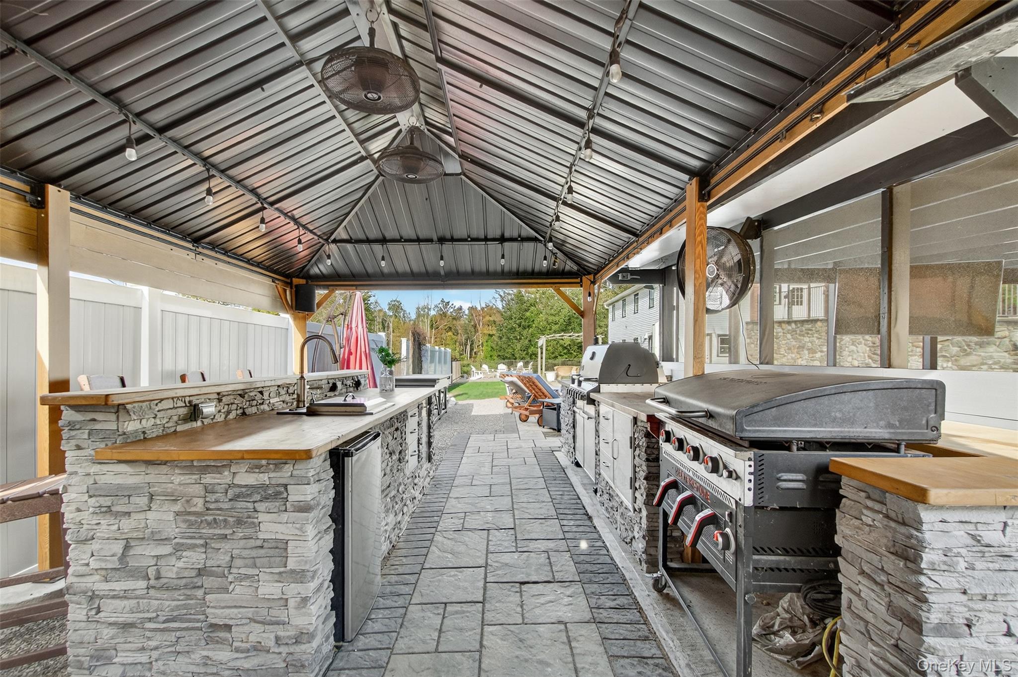 23 Creek Road Staatsburg, NY 12580 - Photo 27 of 39 a view of a kitchen with a table and chairs under an umbrella