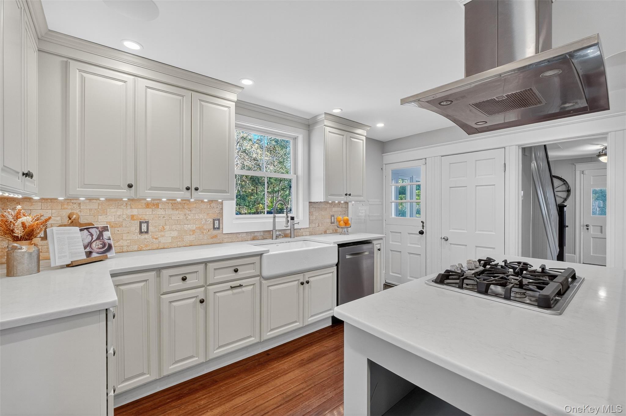 23 Creek Road Staatsburg, NY 12580 - Photo 4 of 39 a kitchen with a sink stove and white cabinets with wooden floor