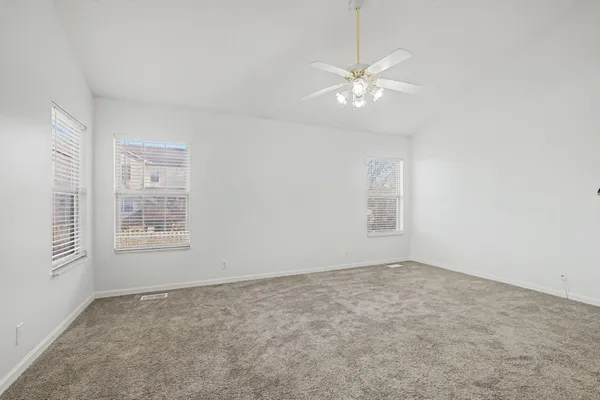 a kitchen with stainless steel appliances kitchen island granite countertop a dining table chairs and a refrigerator