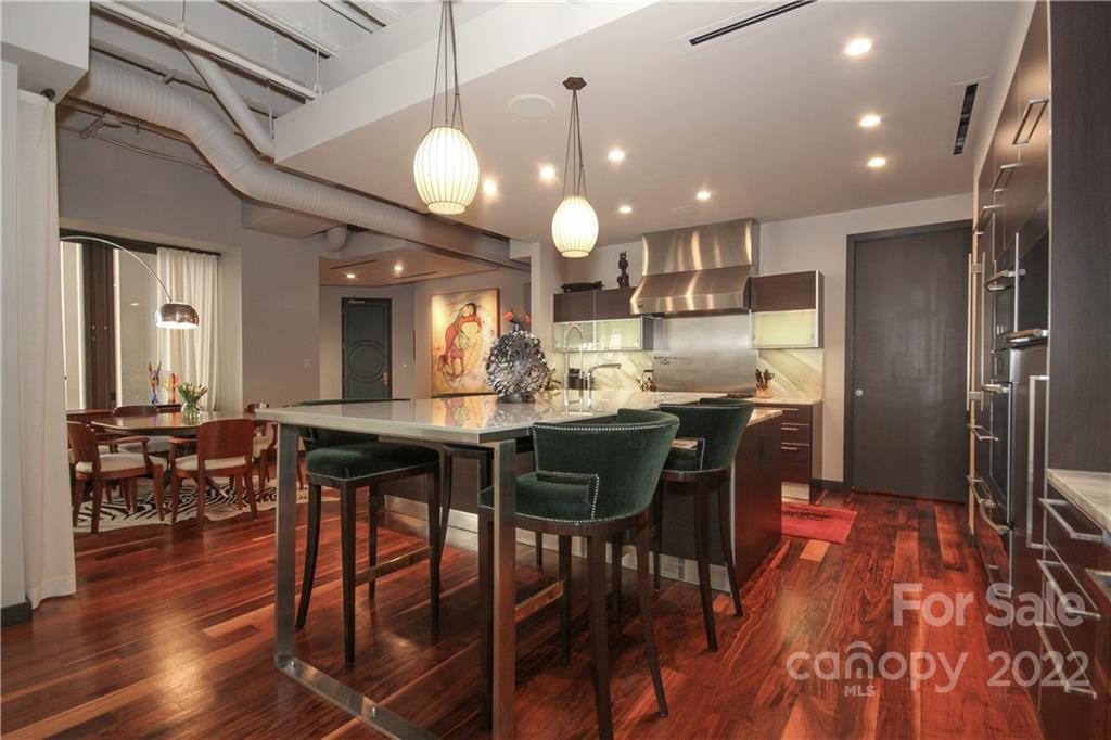 139 South Tryon Street Charlotte, NC 28202 - Photo 17 of 48 a kitchen with stainless steel appliances kitchen island granite countertop a table chairs and a refrigerator