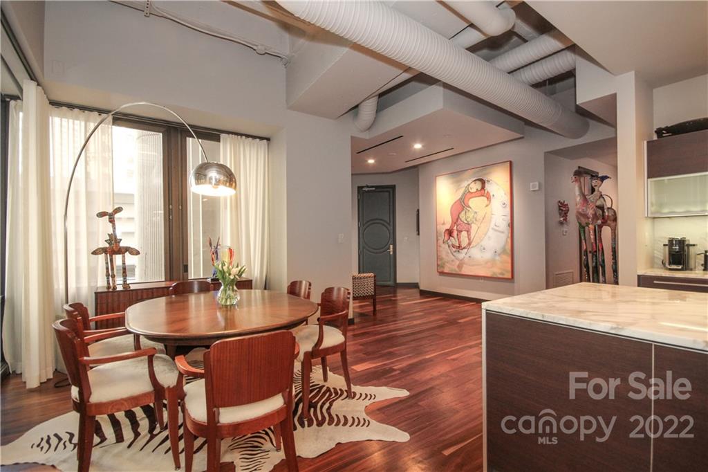 139 South Tryon Street Charlotte, NC 28202 - Photo 23 of 48 a dining hall with couches a dining table and chairs with wooden floor