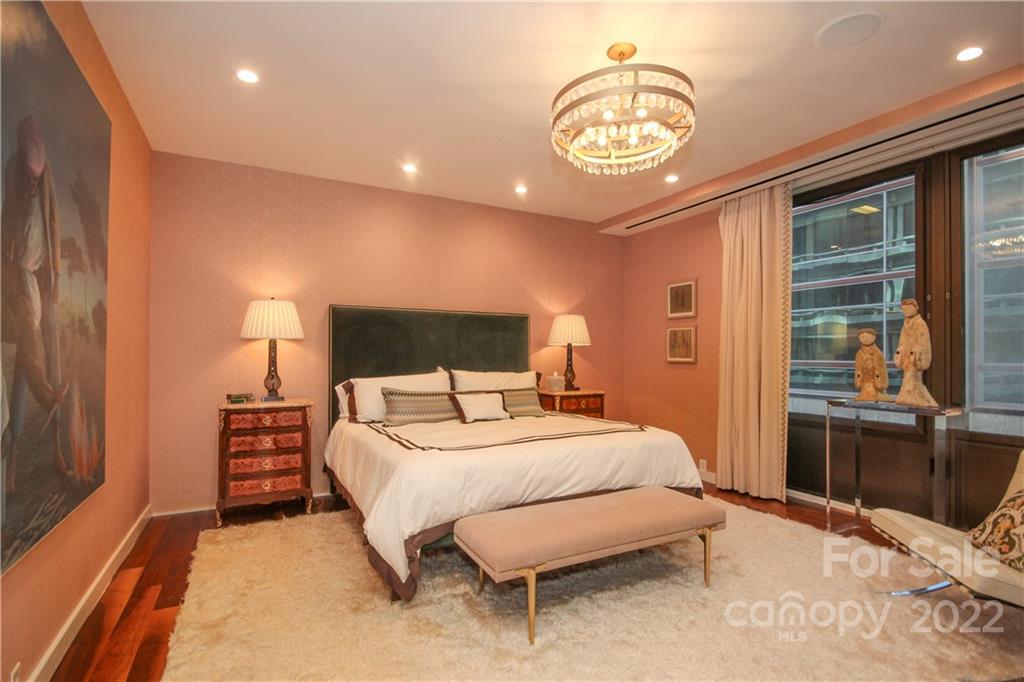 139 South Tryon Street Charlotte, NC 28202 - Photo 28 of 48 a bedroom with a bed and a chandelier