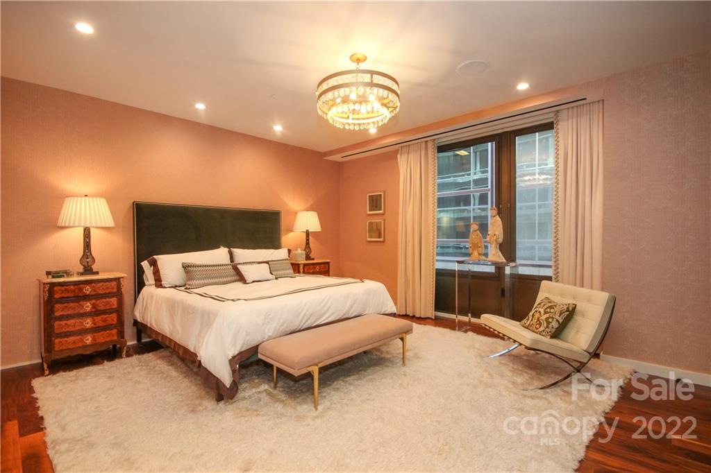 139 South Tryon Street Charlotte, NC 28202 - Photo 31 of 48 a bedroom with a bed and a chandelier