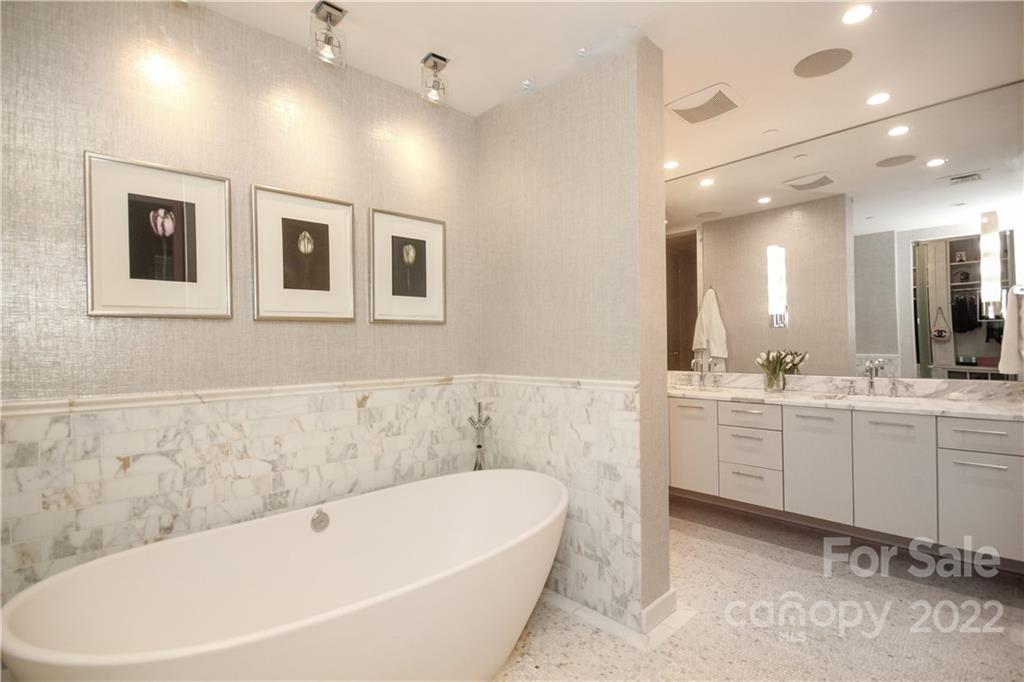 139 South Tryon Street Charlotte, NC 28202 - Photo 32 of 48 a bathroom with a bathtub a double vanity sink and mirror