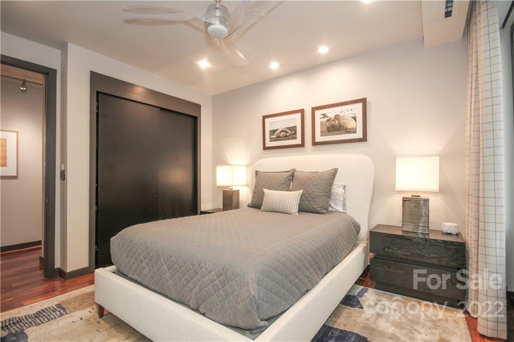 139 South Tryon Street Charlotte, NC 28202 - Photo 40 of 48 a bedroom with a large bed and a chandelier